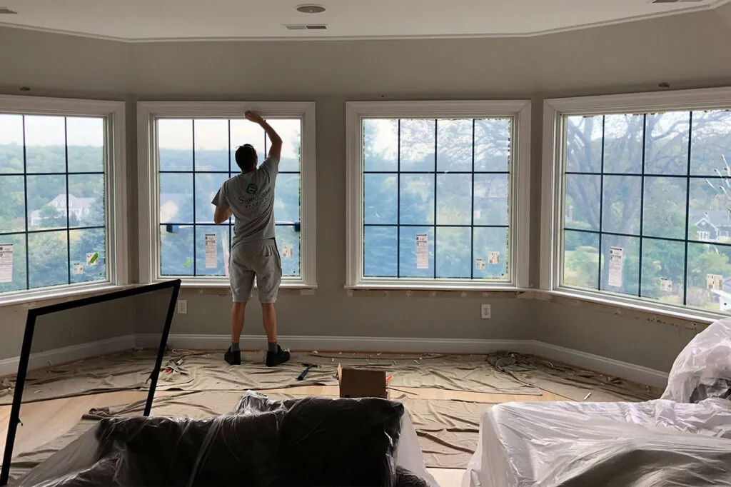 The Renewal by Andersen crew putting the final touches on the window casing in the master.