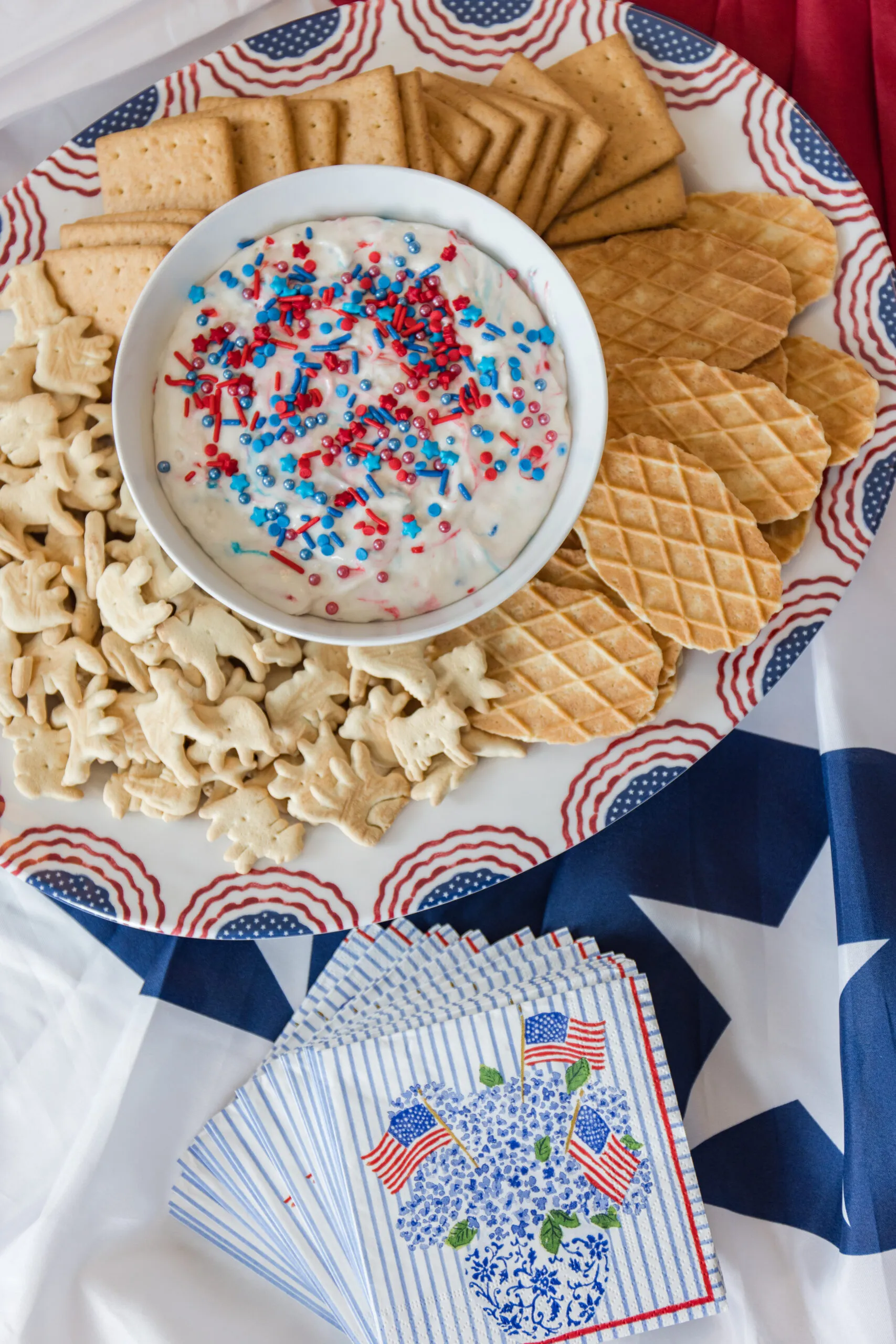 close up image of serving plate with snacks and serving bowl filled with dip for snacks and American flag cocktail napkins