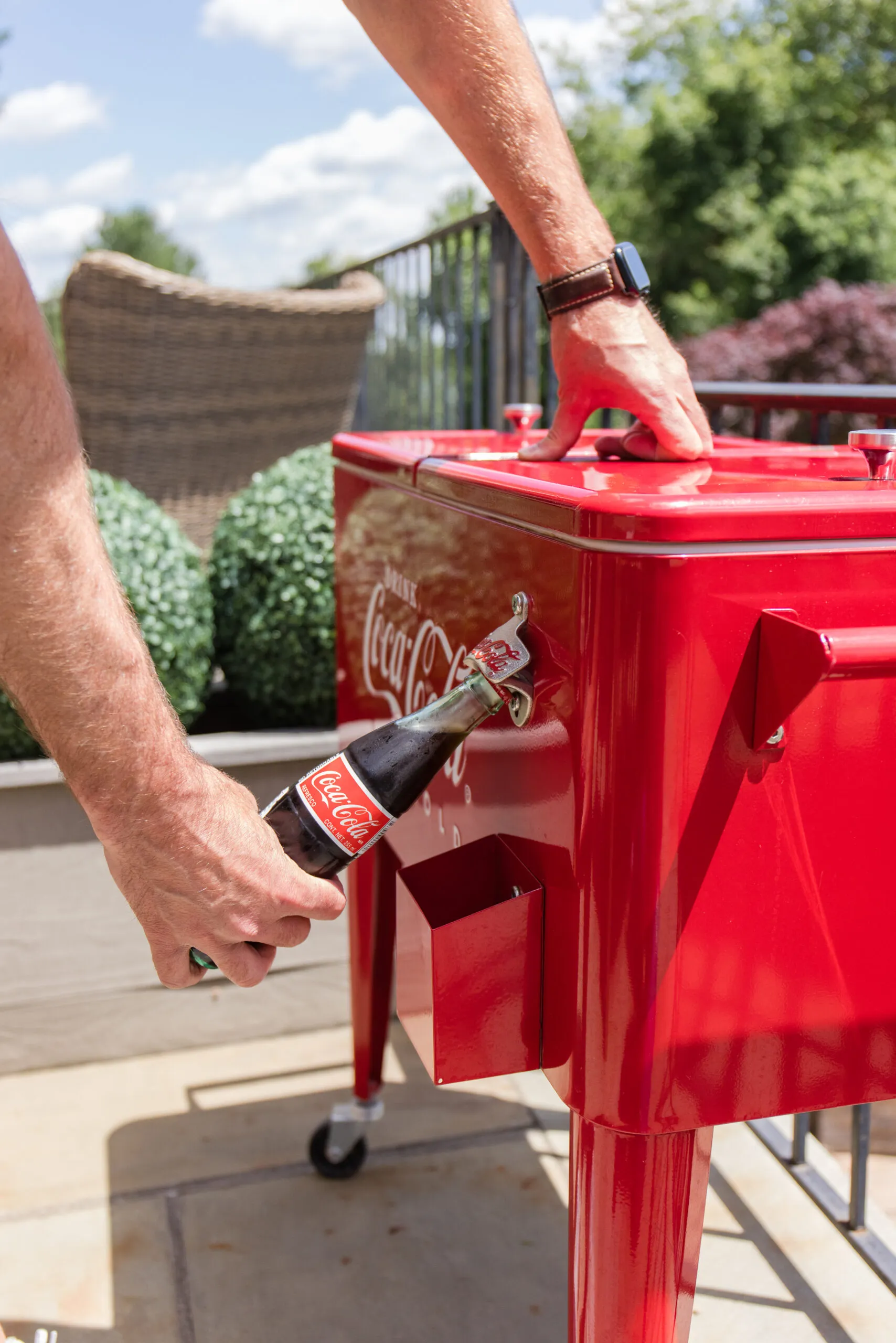 john using the bottle opener on the coca-cola cooler to open his coca-cola drink