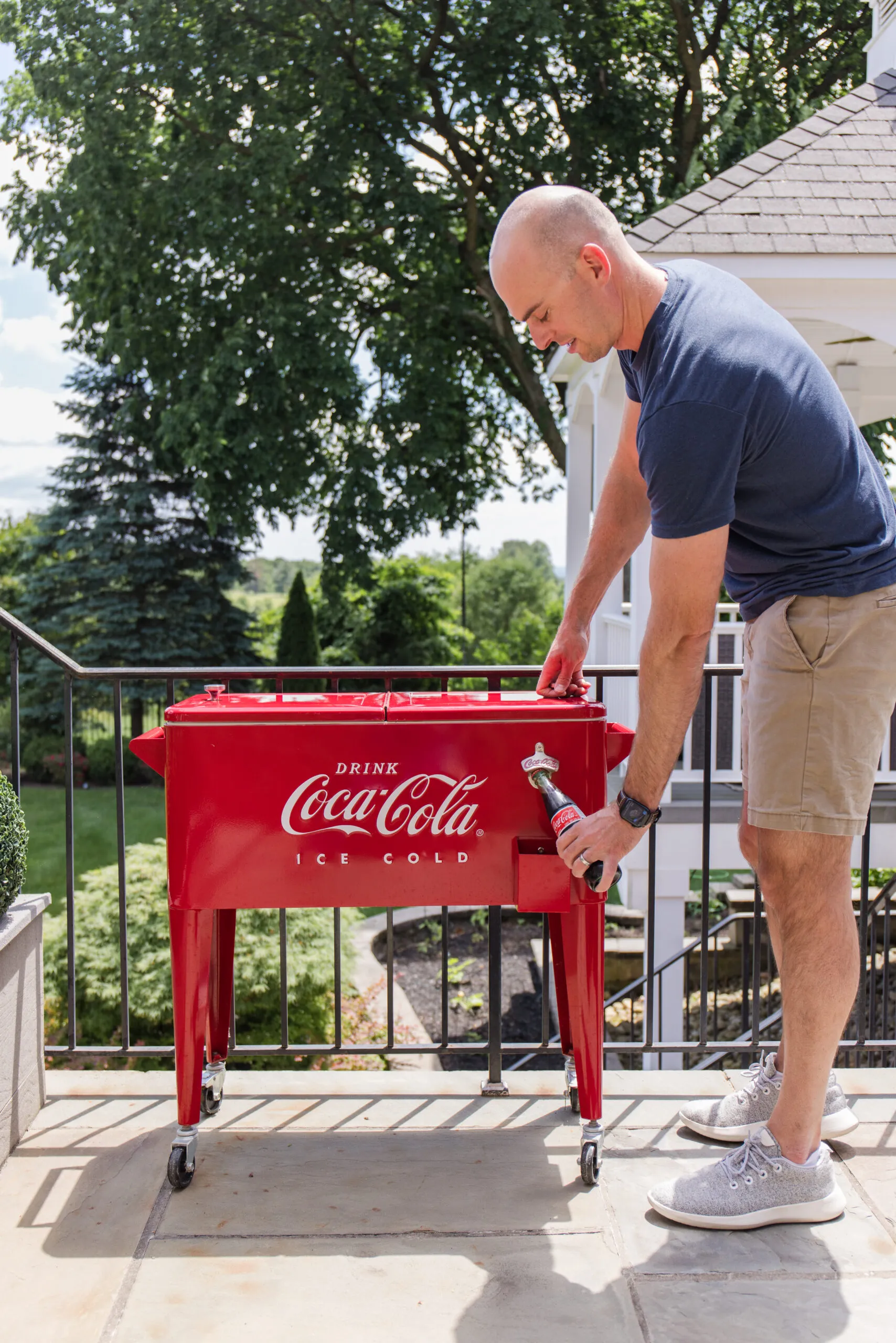 john using bottle opener on coca-cola standing and rolling cooler