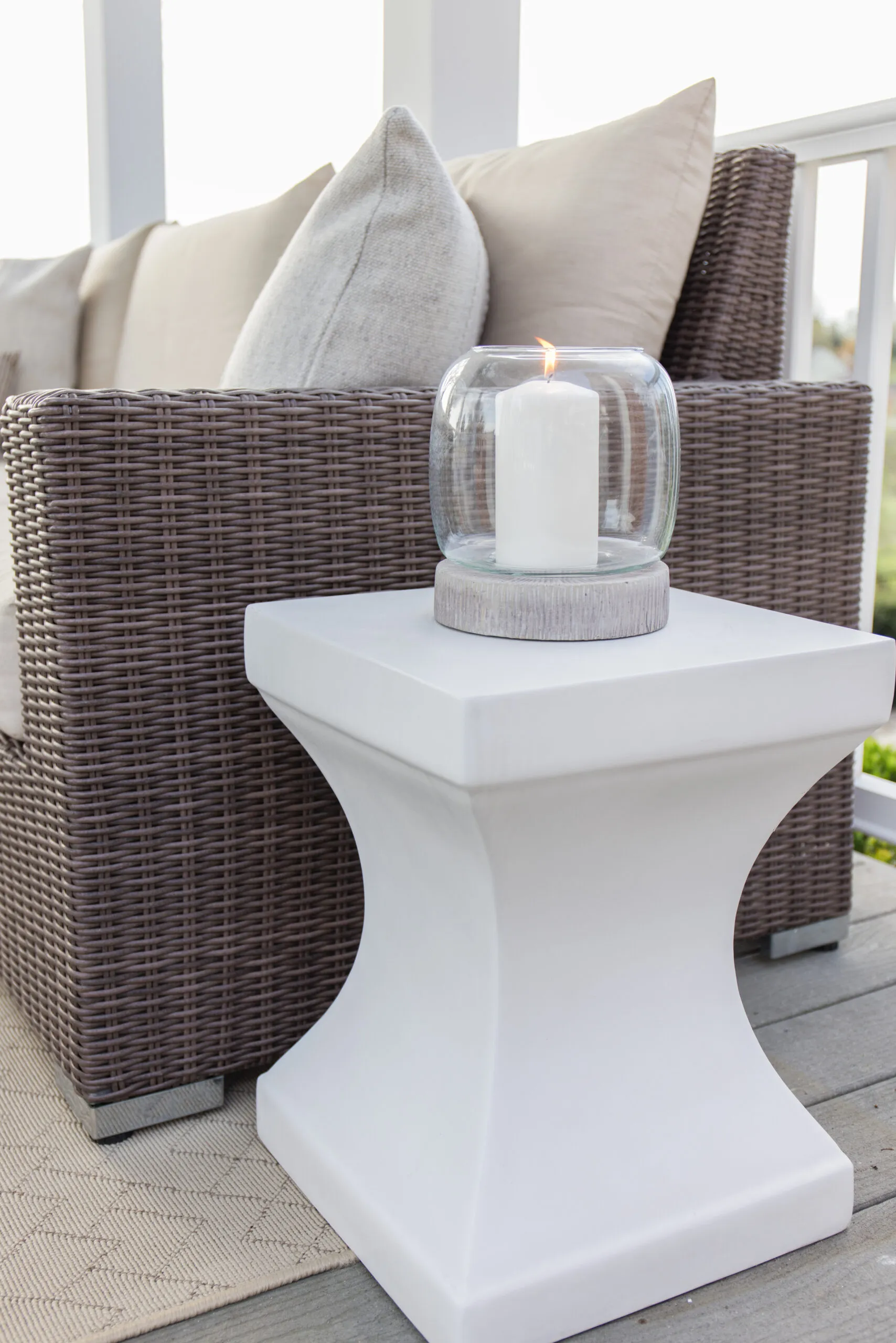 the arched manor outdoor patio styling, white accent table styled with hurricane candleholder