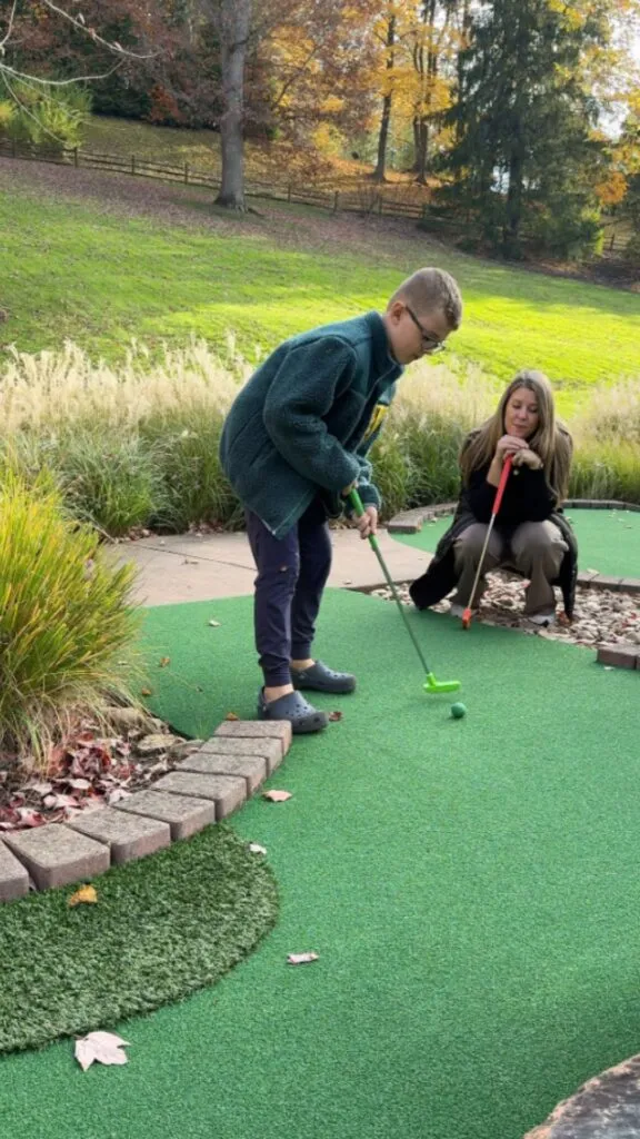 Tristan trying to sink a hole in one on the mini golf course