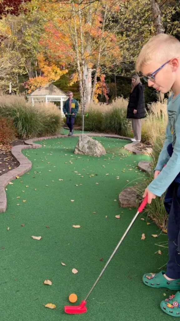 Charlie lining up his put on the mini golf course